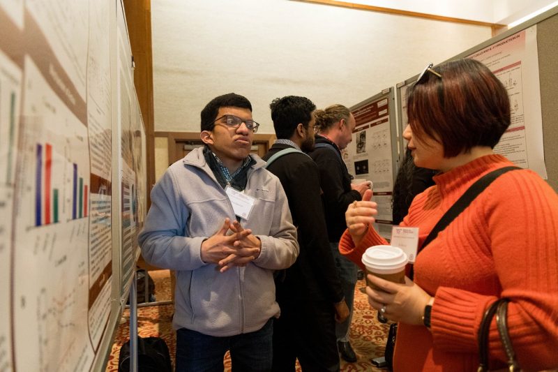 2024 Research Symposium-poster presenter speaking with a reviewer.